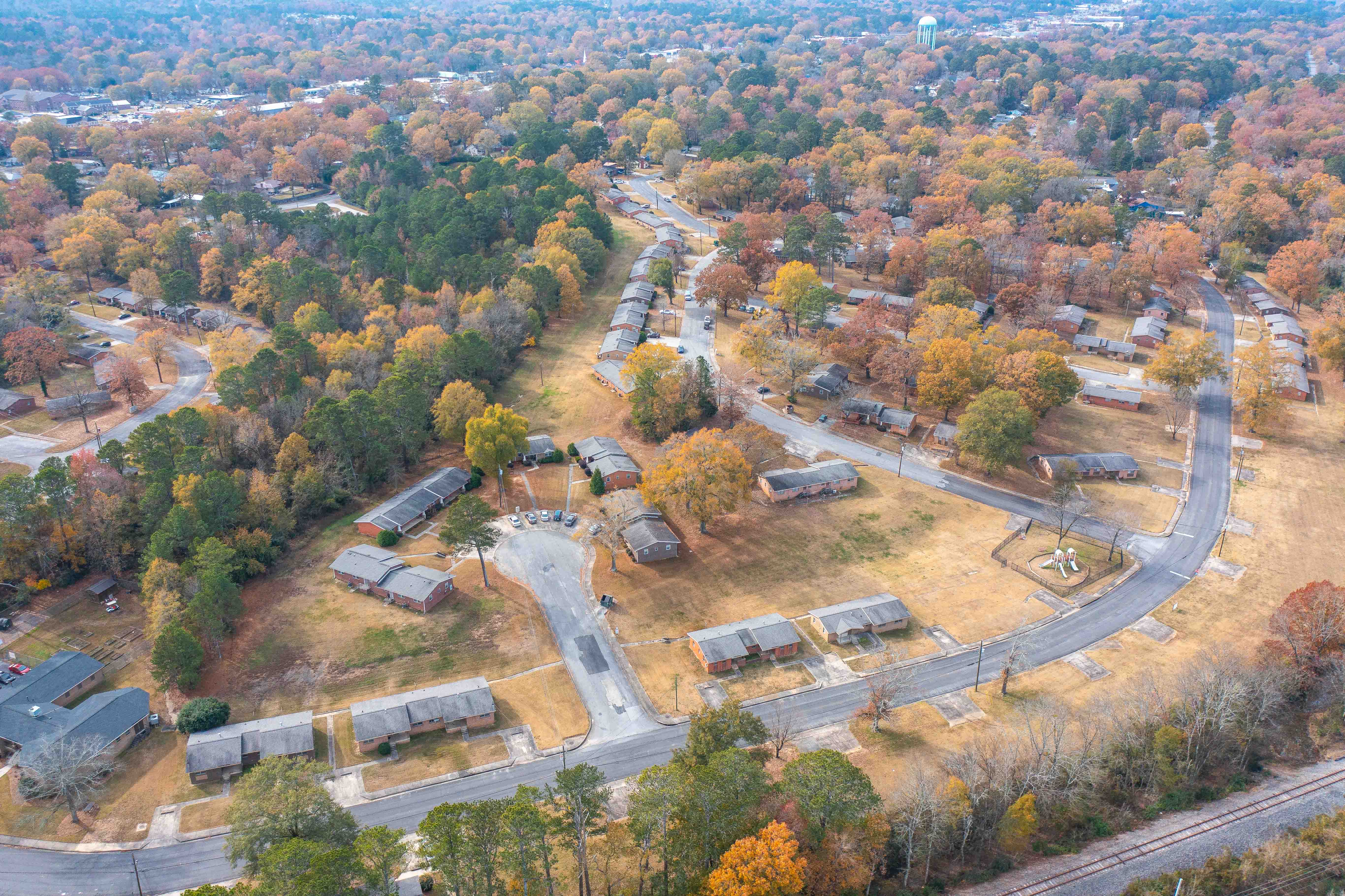 A residential area with houses and trees in autumn colors.